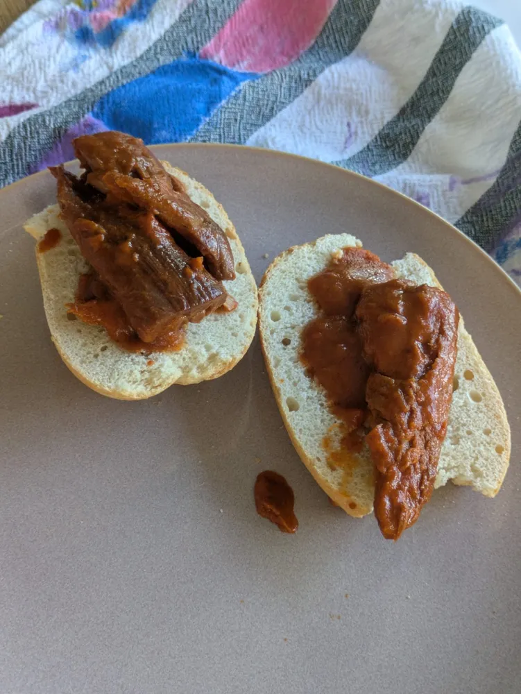 Mackerel fillets in sauce on a roll.