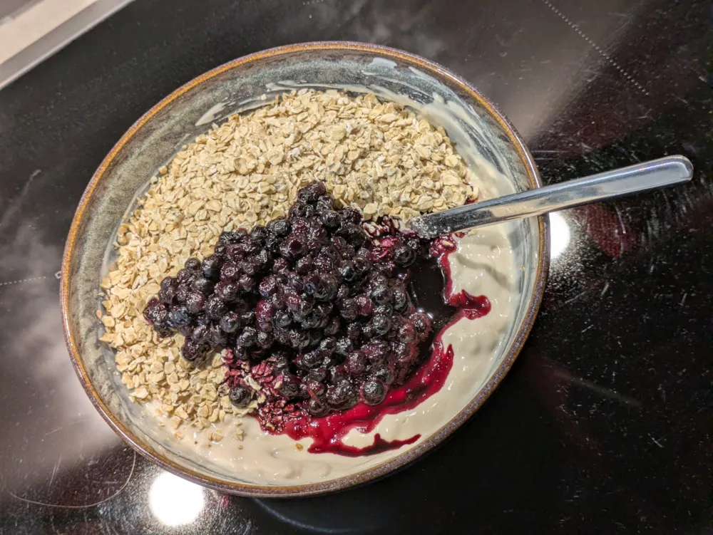 Oats and blueberries on 500 g of soy yogurt, with protein peanut powder underneath.